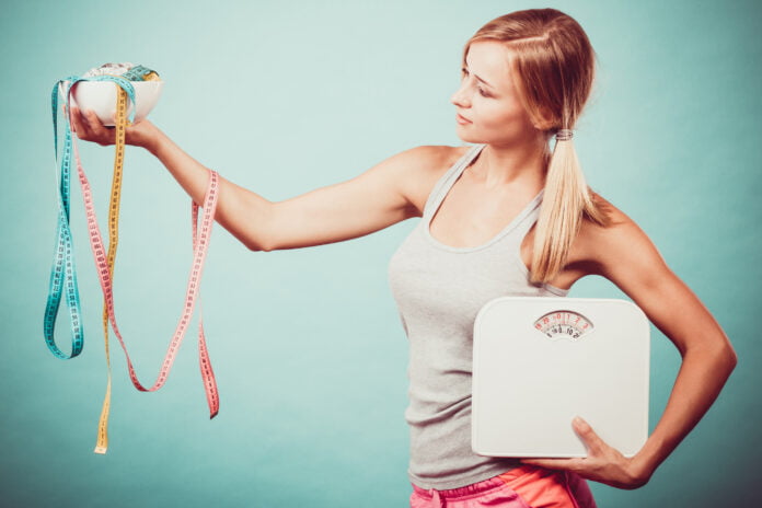 Girl with scales measuring tapes. Weight loss. How To Maintain Ideal Body Weight Naturally